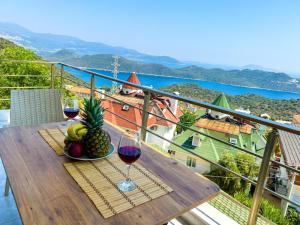 a table with two glasses of wine and a bowl of fruit at Just Dream Suites in Kaş