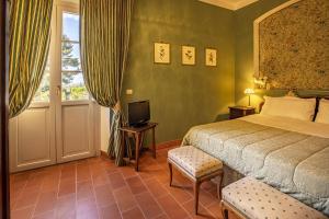 a bedroom with a bed and a television and a window at La Ghirlanda Wine Resort in Saragano