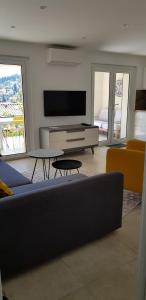 a living room with a couch and a flat screen tv at Bas Villa, Vue mer, Centre ville, Paradis, calme in Hyères