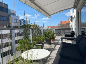uma varanda com um sofá e uma mesa e algumas plantas em Kaupmehe Terrace Apartment, free parking em Taline