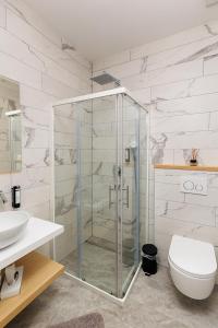 uma casa de banho com uma cabina de duche em vidro e um WC. em Gostilna Müller em Črnomelj