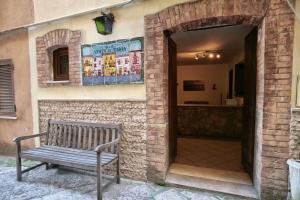 a bench sitting outside of a building with a brick wall at B&B Vento di Terra in Gaeta