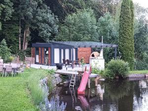 een kleine hut aan de kant van een rivier bij OFFGRID Haus am Angelteich 