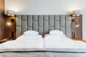 two beds in a hotel room with two lamps at Elements Hotel&Spa in Świeradów-Zdrój