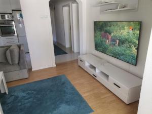 a living room with a flat screen tv on a wall at Garden- pool apartman 