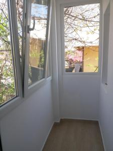 a room with two windows and a wooden floor at EL Mar Sole in Eforie Sud
