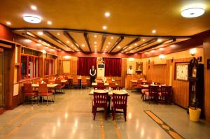 un restaurante con mesas y sillas y un chef de fondo en Hotel Matrix Inn, en Chākan