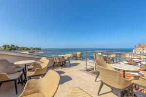 a balcony with chairs and tables and a view of the ocean at Casa Viktor in Umag