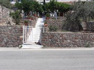 a stone wall with a gate and a stone staircase at Blue on The Beach in Poros