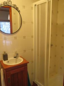 a bathroom with a sink and a shower with a mirror at Casa Capela - Casas do Sinhel in Alvares