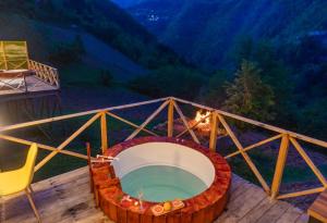 einen Whirlpool auf einer Terrasse mit einem Tisch und Stühlen in der Unterkunft Check Inn Merisi Spa and Resort in Gundauri