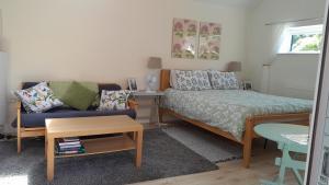 - une petite chambre avec un lit et un canapé dans l'établissement Rosehips at Kerensa, Naburn, à York