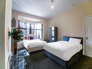 a hotel room with two beds and a window at The Longlands Hotel in Middlesbrough