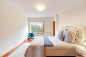 a bedroom with a large bed and a window at São Félix Seaside Oasis in São Félix da Marinha