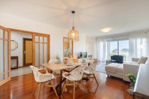 a dining room and living room with a table and chairs at São Félix Seaside Oasis in São Félix da Marinha