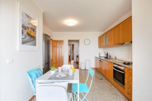 a kitchen with a table and chairs in a room at São Félix Seaside Oasis in São Félix da Marinha