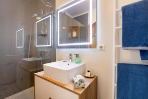 a bathroom with a white sink and a mirror at São Félix Seaside Oasis in São Félix da Marinha