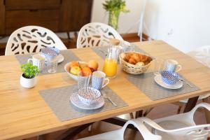 a wooden table with bowls of fruit and baskets of bread at São Félix Seaside Oasis in São Félix da Marinha