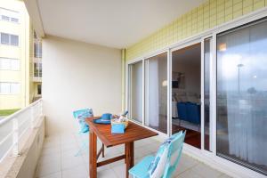 a balcony with a wooden table and two chairs at São Félix Seaside Oasis in São Félix da Marinha