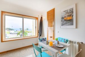 a dining room with a table and chairs and a window at São Félix Seaside Oasis in São Félix da Marinha