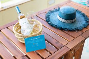 a picnic table with a bottle of wine and a hat at São Félix Seaside Oasis in São Félix da Marinha