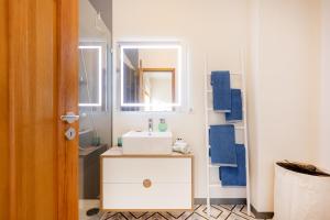 a bathroom with a sink and a mirror at São Félix Seaside Oasis in São Félix da Marinha