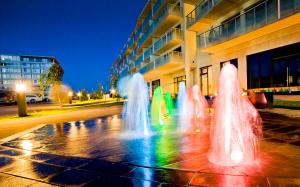 a group of water fountains in front of a building at Aqua Resort Apartments - Pool & Sauna, Aqua Park in Kołobrzeg