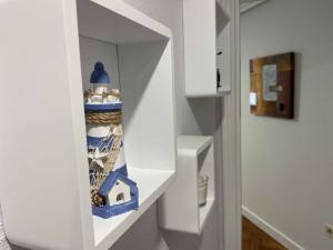 ヒホンにあるBegoña Centro by FlowHomeの花瓶が置かれた棚が付いた白いキャビネット +22枚の写真