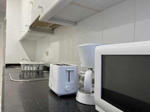 ヒホンにあるBegoña Centro by FlowHomeの電子レンジ付きのカウンタートップを備えたキッチン