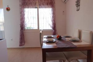 una sala da pranzo con tavolo in legno e finestra di Casa JIRAFA con la vista a Gran Alacant