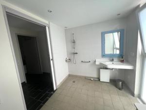 Baño blanco con lavabo y espejo en REPOS SUR L'EAU, en Guidel