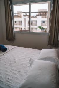 a bed in a bedroom with a large window at CANOA - Boas Vistas in Canoa Quebrada