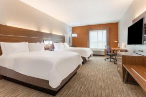 KearneyにあるHoliday Inn Express & Suites Kearney, an IHG Hotelのベッド2台、薄型テレビが備わるホテルルームです。