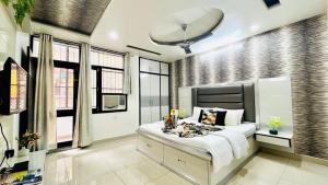 um quarto com uma cama grande e algumas janelas em Olive Service Apartments - Vaishali Nagar em Jaipur