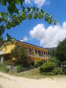 una casa amarilla al lado de una carretera en ABC Rooms en Valdobbiadene