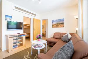 a living room with a couch and a tv at Ferienhof Kluvetasch Appartement Nr 2 - Strandmuschel in Rettin