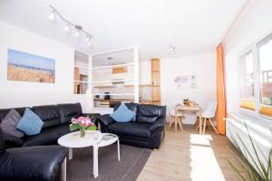a living room with a black couch and a table at Ferienhof Kluvetasch Appartement Nr 4 Ostseeblick in Rettin