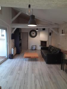 Croix-ChapeauにあるLa campagne dans l'Ocean à LA ROCHELLE les pieds dans la grangeのリビングルーム(ソファ、壁掛け時計付)