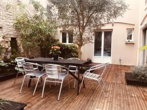 a black table and chairs on a wooden deck at La campagne dans l'Ocean à LA ROCHELLE les pieds dans la grange in Croix-Chapeau