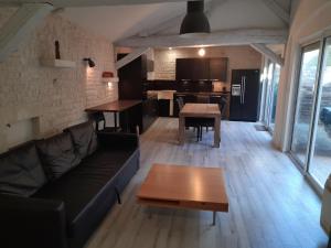 a living room with a couch and a table at La campagne dans l'Ocean à LA ROCHELLE les pieds dans la grange in Croix-Chapeau