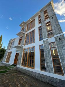 un gran edificio blanco con grandes ventanas en ISLE OF HIGHLAND TOURS Guest House, en Gilgit