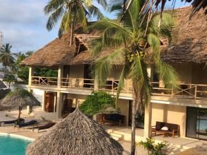 a resort with a swimming pool and a building at The Garden in Paje