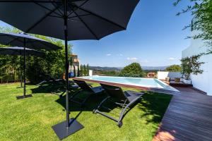 een tafel en stoelen met een parasol en een zwembad bij 4615 Hotel in Felgueiras