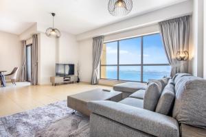 a living room with a couch and a large window at Icon Casa Living - Rimal 3 Residence - JBR in Dubai