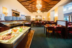 Royal Marianske Lazne في ماريانسكي لازني: مطعم بطاولات وكراسي وبوفيه