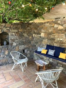 eine Terrasse mit 2 Stühlen, einer Bank und einer Steinmauer in der Unterkunft Saint Joseph in Grimaud