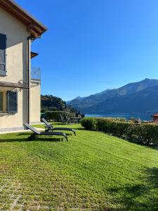 een huis met een gazon met uitzicht op het water bij Lago e Giardino apartment in Bellagio