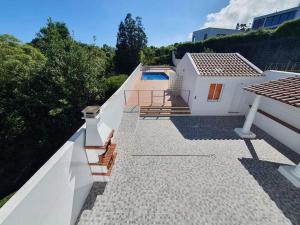 una casa bianca con una piscina sul tetto di Casa dos Amigos a Ponta Delgada