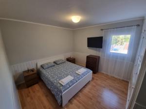 una piccola camera con letto e televisore di Casa dos Amigos a Ponta Delgada Altre 4 foto