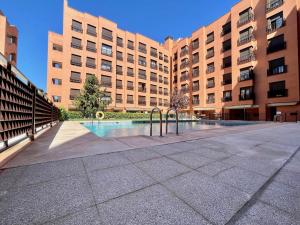 un gran edificio con una piscina frente a él en Apartamento en Madrid en Madrid